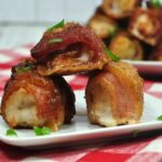 Brown sugar bacon wrapped chicken bites on white plate on the table